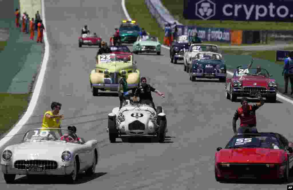 Red Bull driver Max Verstappen, of The Netherlands, center, AlphaTauri driver Pierre Gasly, of France, left, and Ferrari driver Carlos Sainz, of Spain, wave to the crowd during the opening parade of the Brazilian Formula One Grand Prix at the Interlagos race track in Sao Paulo.