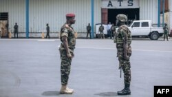 Congolese army deputy chief of staff General Chiko Tshitambwe, left, greets a Kenyan army commander as he lands with his troops at Goma airport, eastern Democratic Republic of Congo, Nov. 12, 2022.