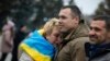 A woman leans on Ukrainian lawmaker and officer Roman Kostenko as they celebrate the recapturing in Kherson, Ukraine, Nov. 12, 2022. 