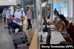 Wisatawan berada di ruang kedatangan internasional di Bandara Internasional Ngurah Rai di Tuban dekat Denpasar, Bali pada 16 Februari 2022. (Foto: AFP/Sonny Tumbelaka)