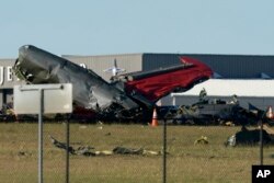Debris from two planes that crashed during an airshow at Dallas Executive Airport lie on the ground Saturday, Nov. 12, 2022.