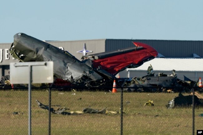 Debris from two planes that crashed during an airshow at Dallas Executive Airport lie on the ground Saturday, Nov. 12, 2022.