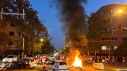 FILE - A vehicle burns during a Sept. 19, 2022 protest of the death of Mahsa Amini, who died after being arrested by "morality police" in Iran. Iran's hardline judiciary has indicted 11 people over the killing of a Basij security force member during unrest, state media reported