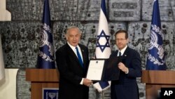 Israel's Likud Party leader Benjamin Netanyahu, left, and President Isaac Herzog pose on the podium after Herzog assigned Netanyahu the task of forming a government, in Jerusalem, Nov. 13, 2022. 