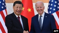 US President Joe Biden (R) and China's President Xi Jinping (L) shake hands as they meet on the sidelines of the G-20 Summit in Nusa Dua on the Indonesian resort island of Bali, Nov. 14, 2022.