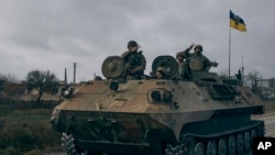 Ukrainian soldiers ride a captured Russian APC in Kherson, Ukraine, Sunday, Nov. 13, 2022.