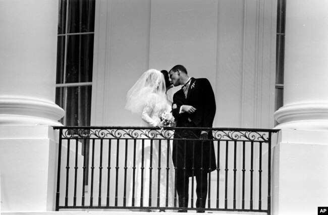 FILE - Newlyweds Luci Baines Johnson and Patrick J. Nugent as they kiss on the White House balcony in Washington, Aug. 6, 1966.