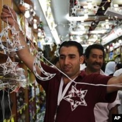 A Palestinian souvenir shop owner displays decoration lights of Ramadan at his shop in the West Bank city of Ramallah, July 31, 2011