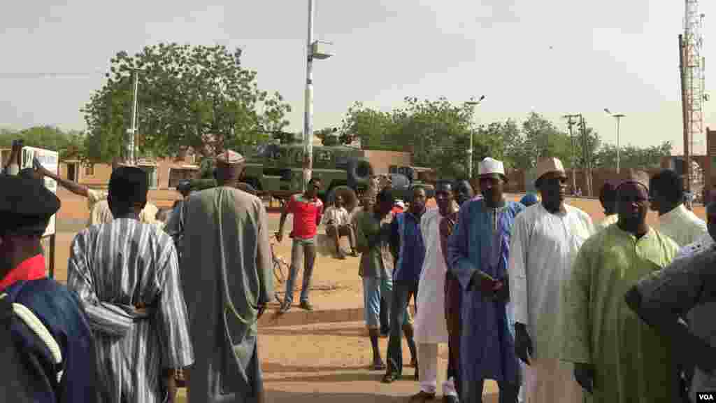 In Daura, hometown of APC presidential candidate General Muhammadu Buhari, a Nigerian Army armored attack vehicle and two military pickups sit outside the emir&#39;s palace across from a polling unit where people are lined up to vote.