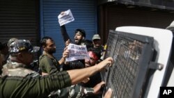 Indian policemen detain Kashmiri Shiite Muslims as they shout pro-freedom slogans after they made an attempt at a religious procession during restrictions in Srinagar, Indian controlled Kashmir, Sept. 8, 2019.