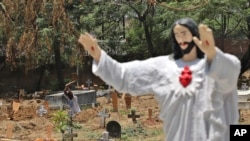 印度工人在新德里一处基督徒墓地里为埋葬新冠死者做准备。（2021年5月21日）