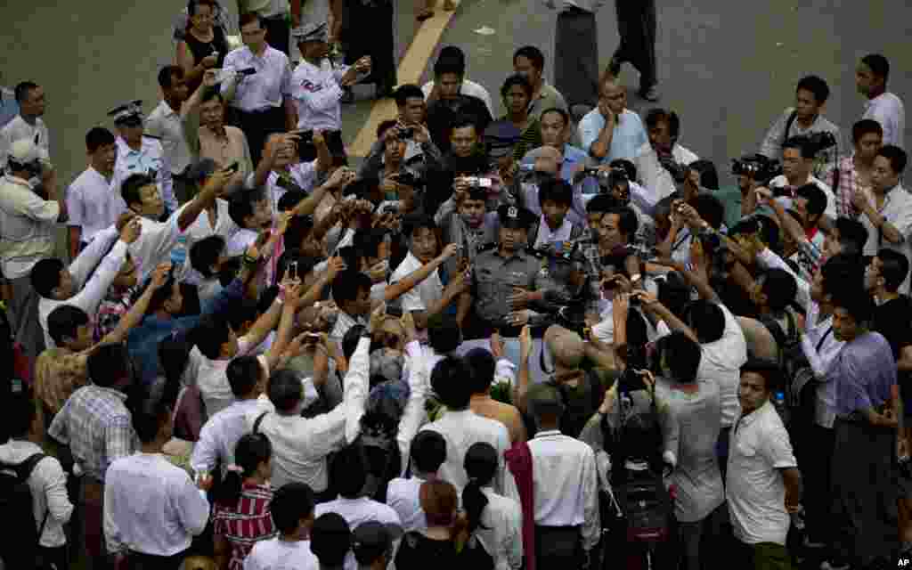 Burmese police officers are surrounded by a small group of pro-democracy students marching to commemorate the August 8,1988 uprising, Rangoon, August 8, 2013.