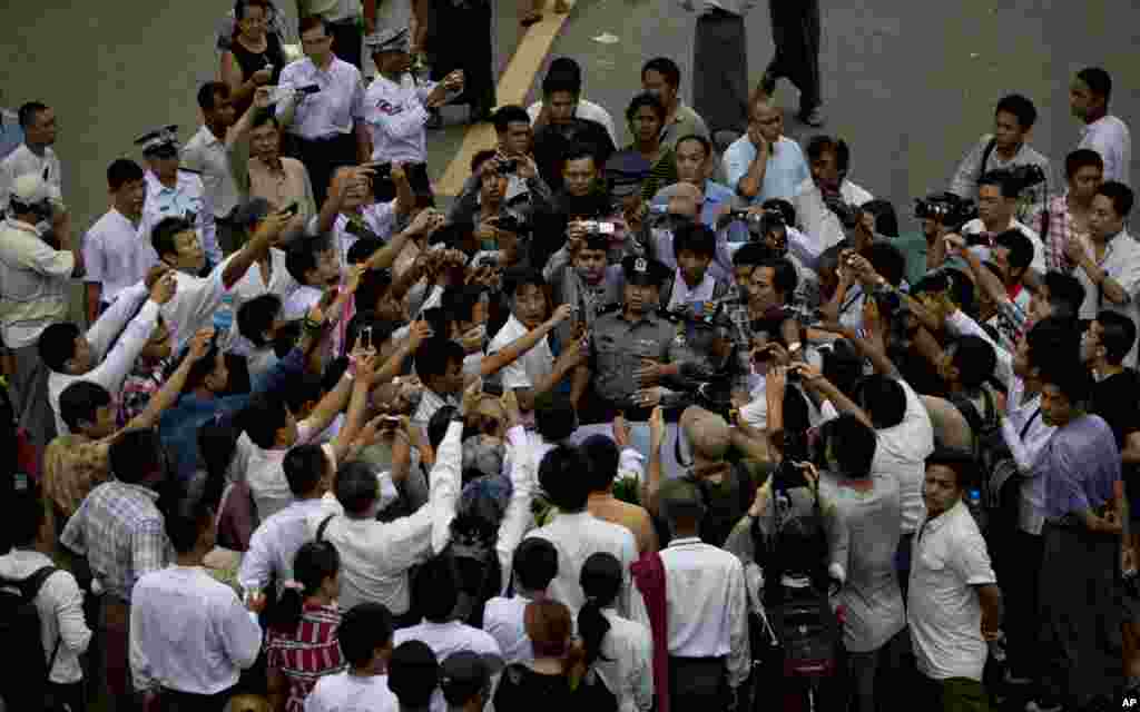 Burmese police officers are surrounded by a small group of pro-democracy students marching to commemorate the August 8,1988 uprising, Rangoon, August 8, 2013. 