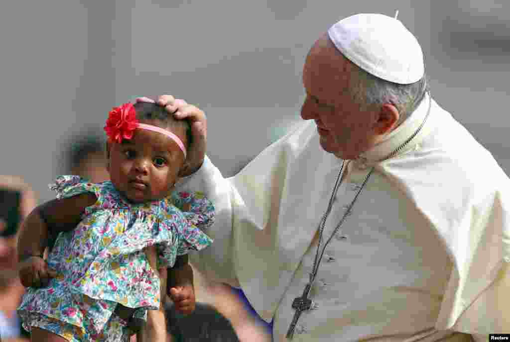로마 바티칸 성 베드로 광장에서 열린 수요 일반 알현 미사에서 프란시스 교황이 아이에게 안수기도를 해 주고 있다.