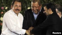 El presidente de Nicaragua, Daniel Ortega, se toma las manos con su homólogo venezolano, Hugo Chávez (centro), y el mandatario iraní, Mahmoud Ahmadinejad (izquierda).