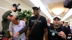 Former NBA basketball star Dennis Rodman, center, arrives at Sunan International Airport on June 13, 2017, in Pyongyang, North Korea. 