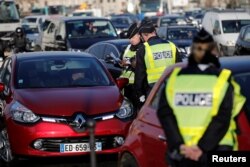French policemen check automobile registration plates as authorities imposed alternate vehicle circulation days to reduce car traffic and pollution in Paris, Dec. 6, 2016.