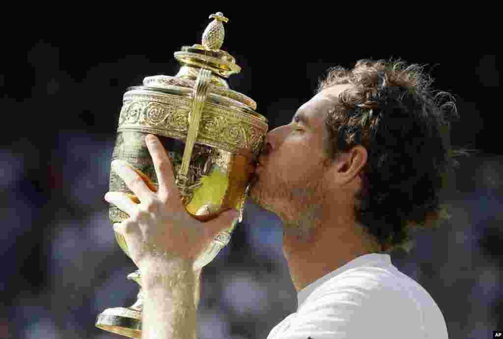 Andy Murray of Britain kisses his trophy after beating Milos Raonic of Canada in the men&#39;s singles final on day fourteen of the Wimbledon Tennis Championships in London.