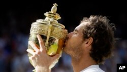 Andy Murray of Britain kisses his trophy after beating Milos Raonic of Canada in the men's singles final on day fourteen of the Wimbledon Tennis Championships in London, July 10, 2016. 
