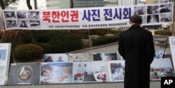 FILE - A man looks at photos showing North Korean children suffering from famine, at a photo exhibition in Seoul, South Korea, Feb. 27, 2014.
