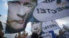People rally in support of Crimea joining Russia, with banners and portraits of Russian President Vladimir Putin, reading 'We are Together,' in Red Square in Moscow, Tuesday, March 18, 2014.