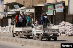 Vehicles carrying children drive past stacked sandbags in the town of Tabqa, after Syrian Democratic Forces (SDF) captured it from Islamic State militants this week, Syria May 12, 2017.