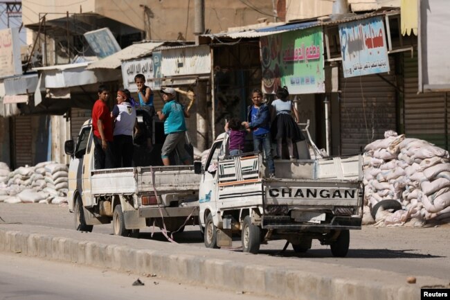 Vehicles carrying children drive past stacked sandbags in the town of Tabqa, after Syrian Democratic Forces (SDF) captured it from Islamic State militants this week, Syria May 12, 2017.