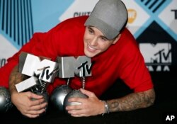 Justin Bieber poses with his awards during a photo call at the 2015 MTV European Music Awards in Milan, Italy, Oct. 25, 2015.