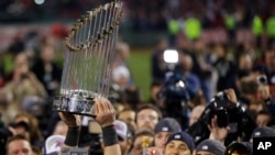 A player holds up the championship trophy after defeating the St. Louis Cardinals in Game 6 of baseball's World Series Wednesday, Oct. 30, 2013.