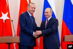 블라디미르 푸틴 러시아대통령과(오른쪽) 레제프 타이이프 에르도안 터키 대통령이 17일 러시아 소치에서 기자회견을 가진 후 악수하고 있다.