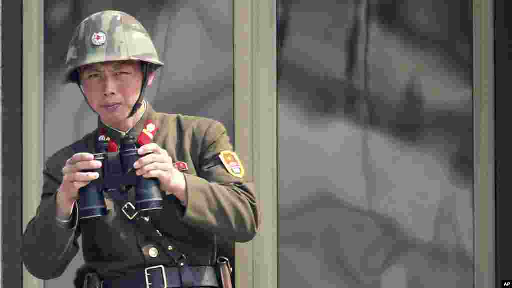 4月4日一名朝鲜士兵在边界附近的村庄板门店观察韩国那边的动静。