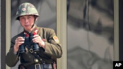 A North Korean soldier watches the South Korean side at the border village of Panmunjom in the demilitarized zone (DMZ) in South Korea, April 4, 2013.