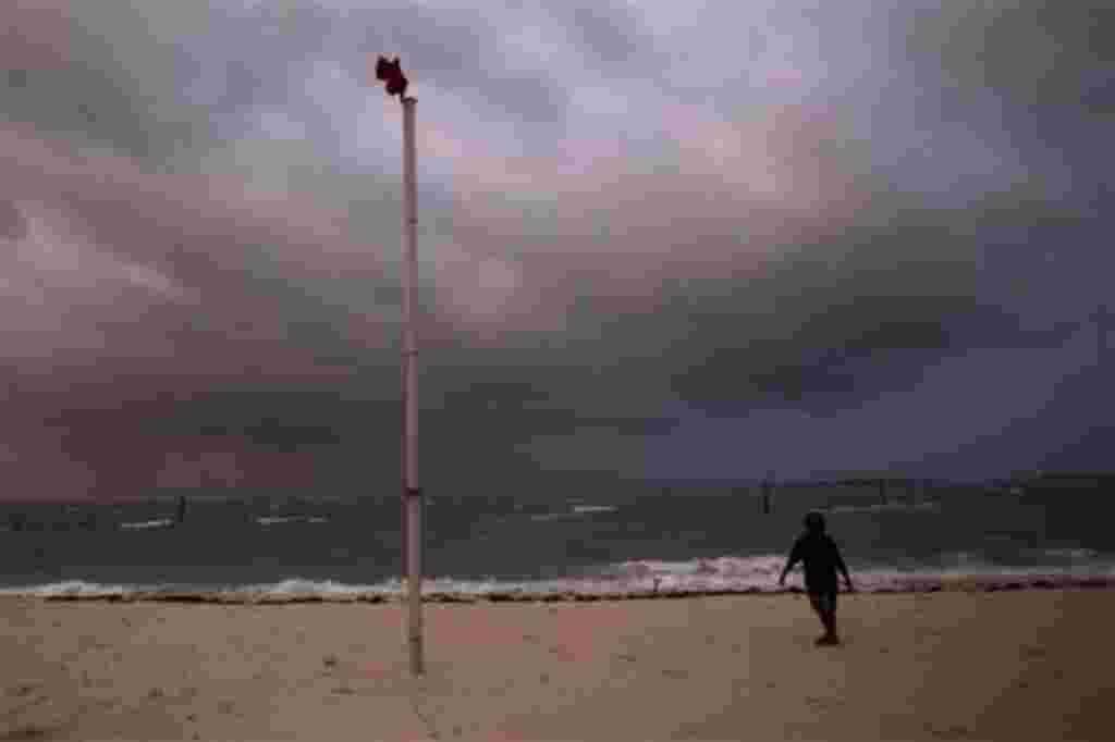 Un niño camina por la playa golpeado por las bandas de lluvia y el viento que viene a través del huracán Irene en Nassau, en Isla Nueva Providencia en las Bahamas, 24 de agosto de 2011.