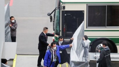Cảnh sát Nhật áp giải hai bố con ông Taylor tại phi trường Narita ngày 2/3/2021.