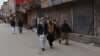 People walk past shops closed because of a strike called to condemn the death of prominent Pashtun rights activist Arman Luni, in Quetta, Pakistan, Feb. 4, 2019. 