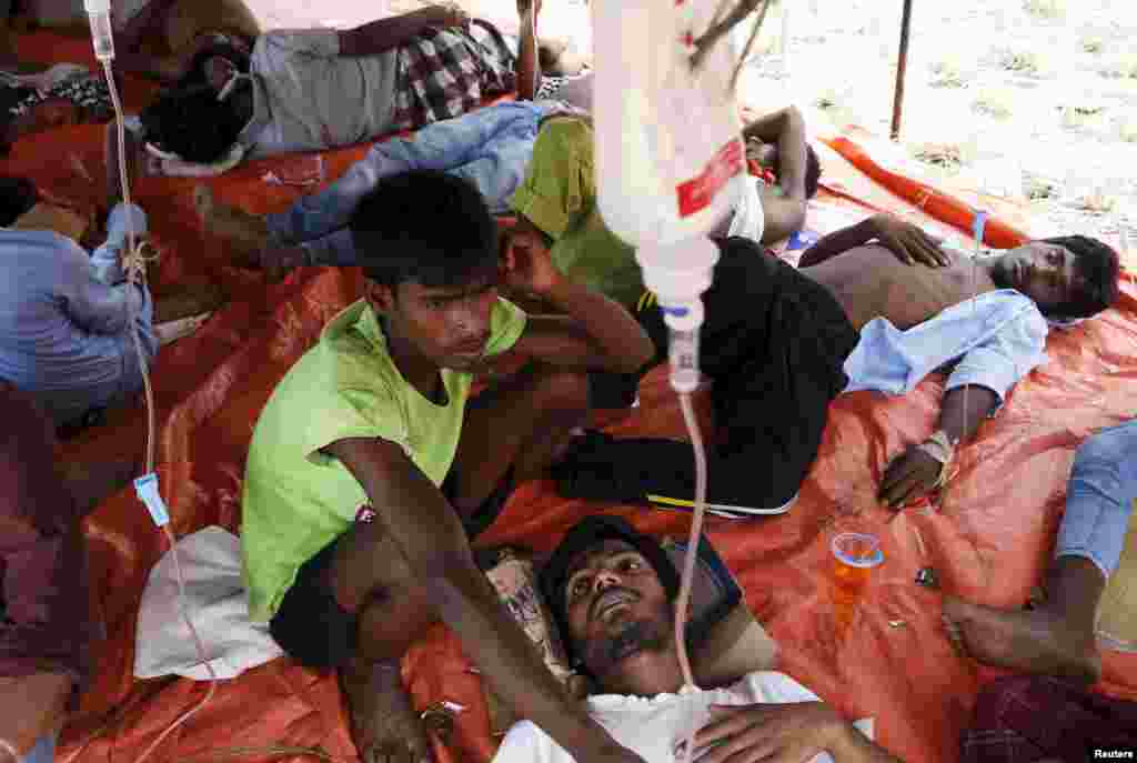 Para migran Rohingya, yang tiba di Indonesia dengan kapal, menerima perawatan medis di dalam tempat penampungan sementara di Kuala Langsa, di Aceh (16/5). (Reuters/Beawiharta)