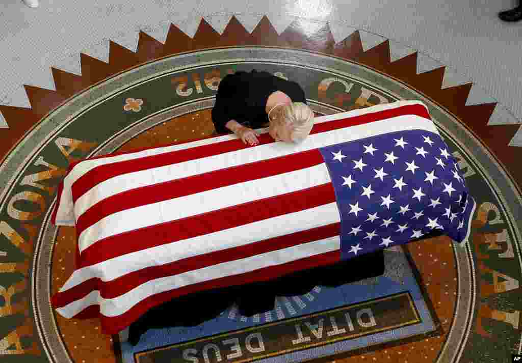 Cindy McCain, wife of the late Sen. John McCain, R-Ariz. lays her head on casket during a memorial service at the Arizona Capitol, Aug. 29, 2018, in Phoenix, Arizona.