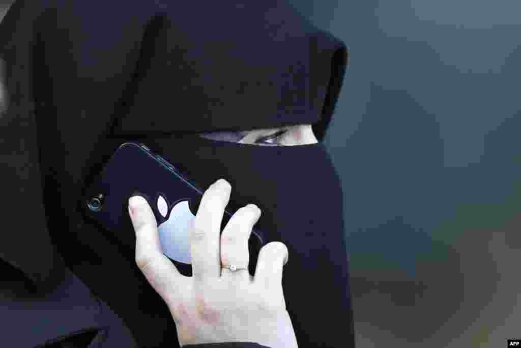 A women, wearing a niqab despite a nationwide ban on the Islamic face veil, gives a phone call outside the courts in Meaux, east of Paris, September 22, 2011. REUTERS/Charles Platiau