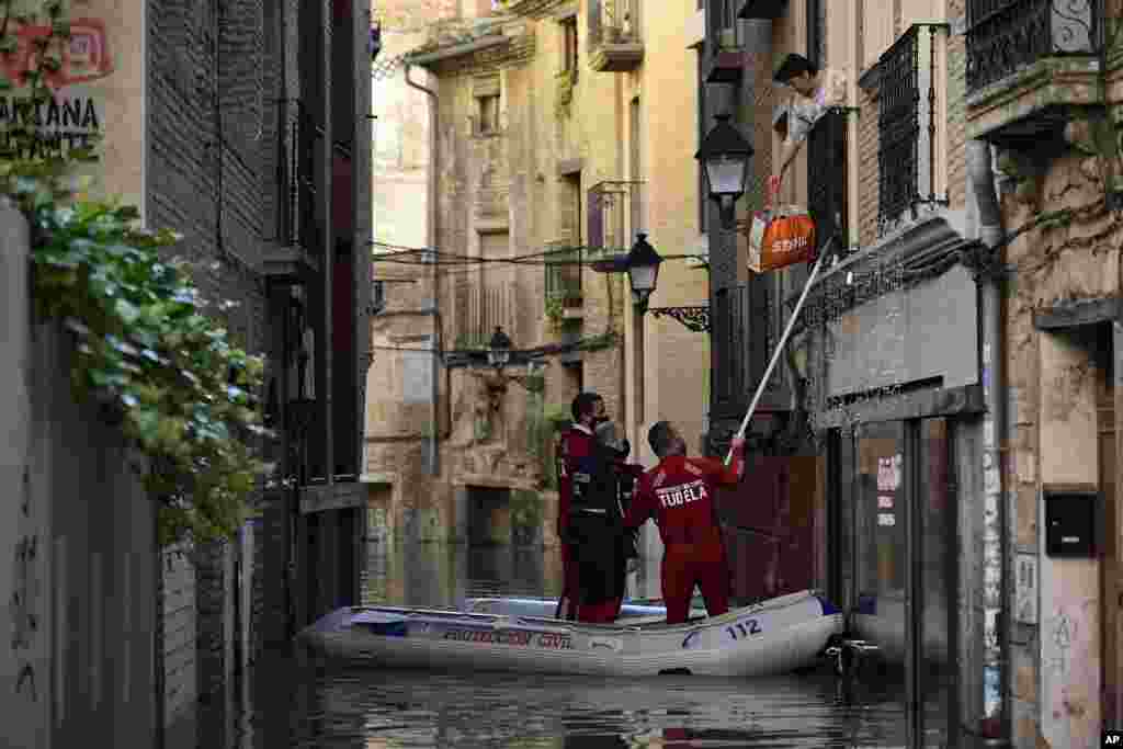 A rescue team helps a woman in her home in a flooded area near the Ebro River in Tudela, northern Spain.