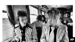 David Bowie (L) and friend travel by train in 1973. (Copyright Mick Rock 2012)