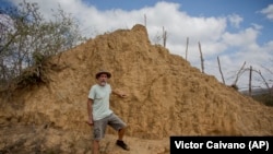 American botanist Roy Funch poses next to a giant termite mound near Barauna, Brazil, Friday, Nov. 23, 2018.