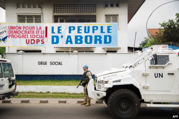 FILE - A peacekeeper of the MONUSCO, the U.N. mission in the Democratic Republic of Congo, stands guard in front of the offices of the main opposition Union for Democracy and Social Progress (UDPS) party, in Kinshasa, Sept. 20, 2016