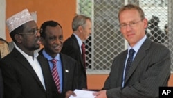 Somali President Sheik Sharif Sheik Ahmed (L) receives diplomatic credentials from the Britain's new ambassador to Somalia Matt Baugh (R) at the Hilltop presidential palace in Mogadishu, Somalia, February 2, 2012.