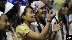 Jennifer Min, 13, photographs the stage where Burmese democracy leader Aung San Suu Kyi speaks in Fort Wayne, Indiana, September25, 2012. 