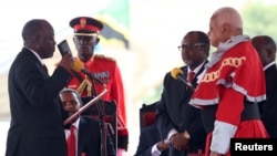 FILE - Tanzania's President-elect John Magufuli (L) takes the Oath of Office during his inauguration ceremony at the Uhuru Stadium in Dar es Salaam, Nov. 5, 2015. 