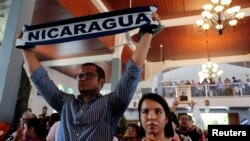 An anti-government protester holds a scarf with the name of Nicaragua during a Palm Sunday Mass in Esquipulas, Nicaragua, April 14, 2019. 