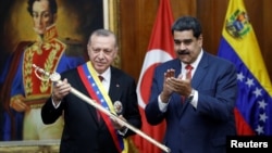 Presiden Turki Recep Tayyip Erdogan memegang replika pedang pahlawan nasional Venezuela Simon Bolivar, bersama Presiden Venezuela Nicolas Maduro, saat kunjungannya di Istana Miraflores, Caracas, Venezuela, 3 Desember tahun lalu (foto: dok). 