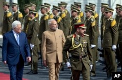 Palestinian President Mahmoud Abbas, left, and Indian Prime Minister Narendra Modi inspect an honor guard upon his arrival at Palestinian Authority headquarters in the West Bank city of Ramallah, Feb. 10, 2018.