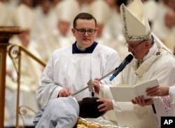 Pope Francis baptizes a child during a solemn Easter vigil ceremony in St. Peter's Basilica at the Vatican, April 15, 2017.