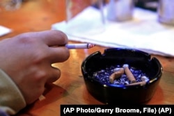 A person holds a cigarette in Durham, N.C., Dec. 2009 (AP Photo/Gerry Broome)